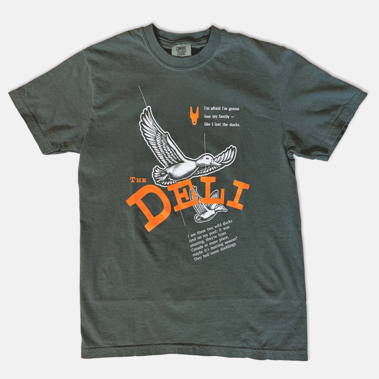 Green t-shirt with a graphic featuring two ducks and text from a Soprano's episode